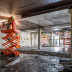 Worker welding at construction site while standing on scissor lift